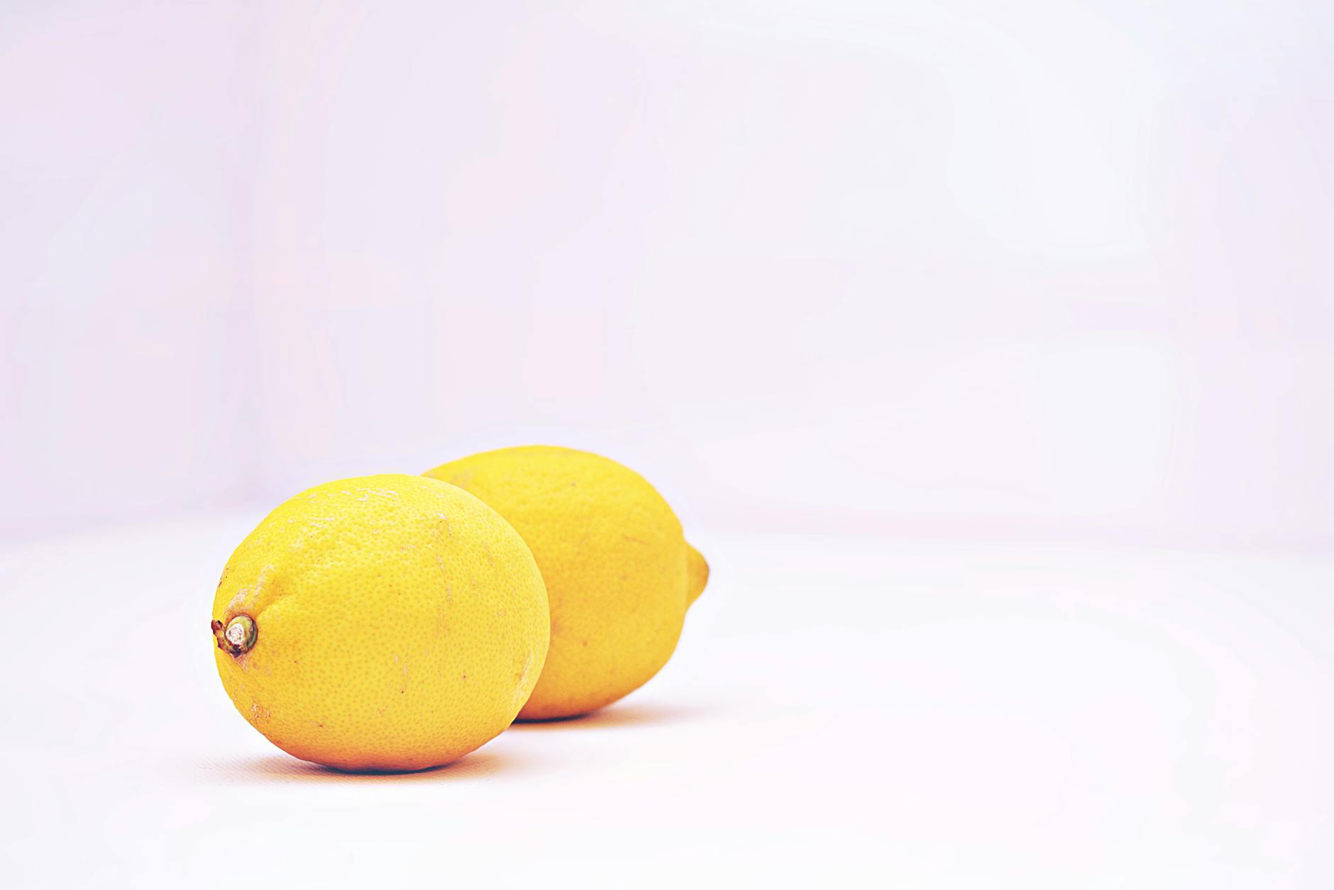Fresh vibrant lemons against a minimalistic white background, representing renewal and freshness after sleep deprivation recovery.
