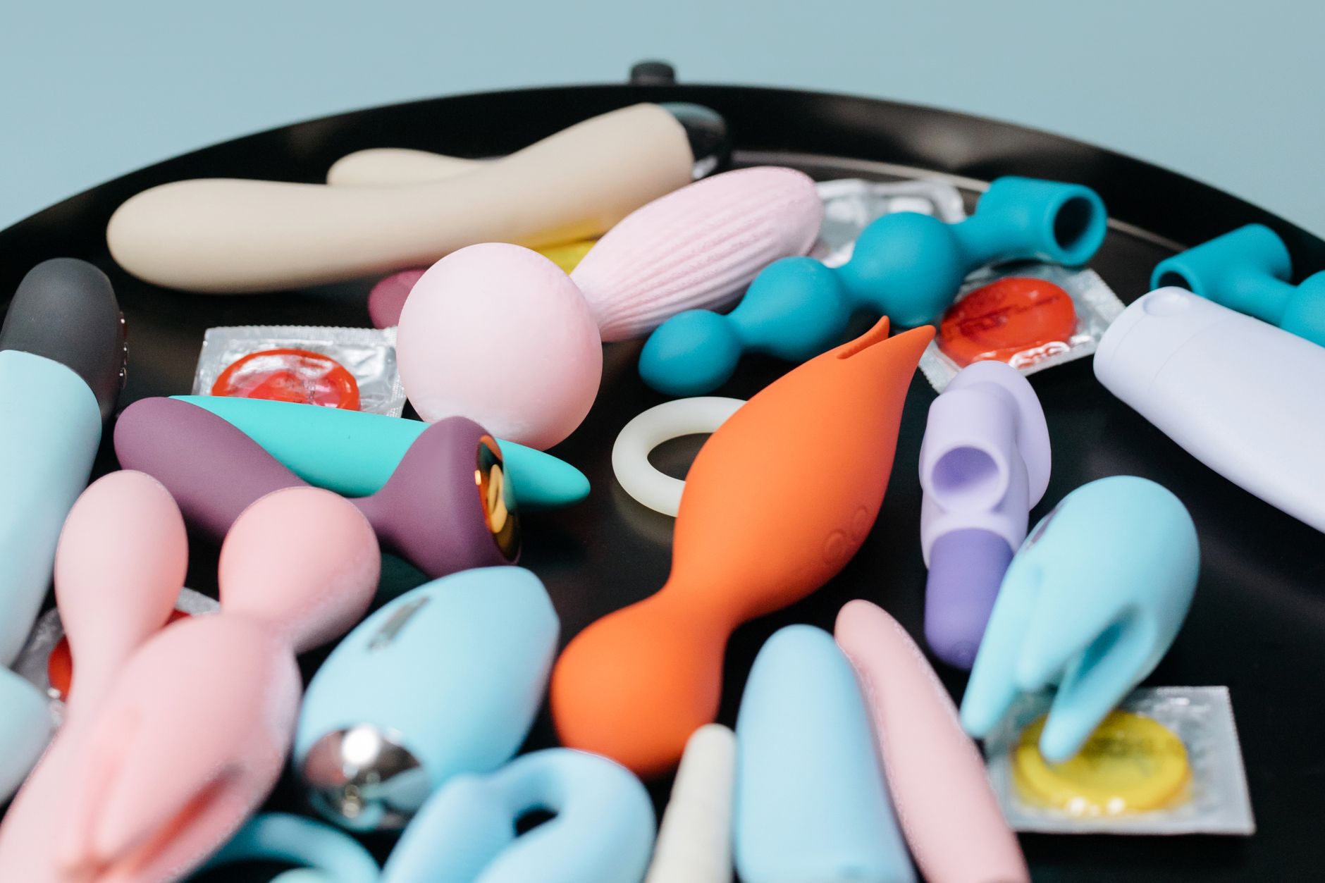 A blue silicone clitoral vibrator held gently in hand, symbolizing intentional pleasure and self-discovery