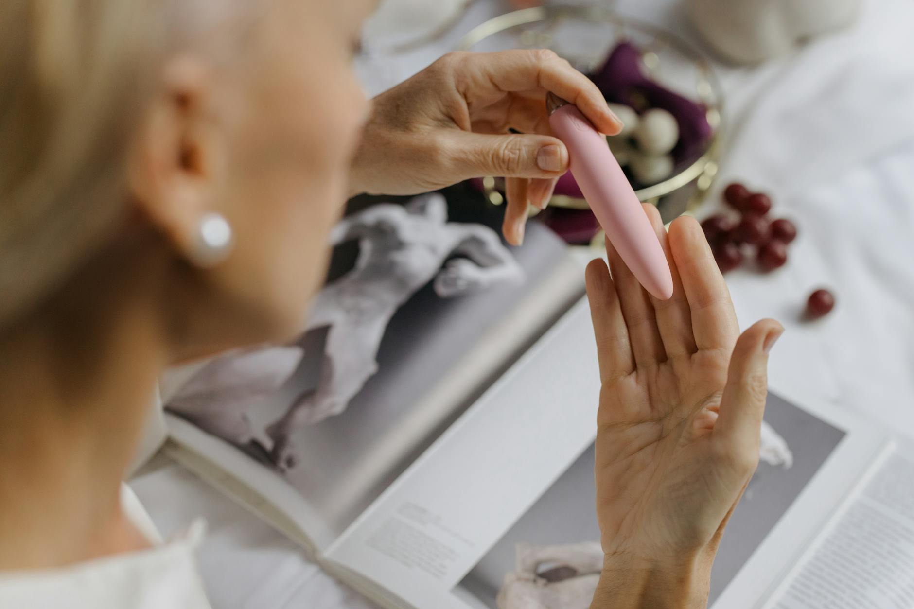 Close-up of hands exploring a pink vibrator, symbolizing intentional pleasure practices in midlife