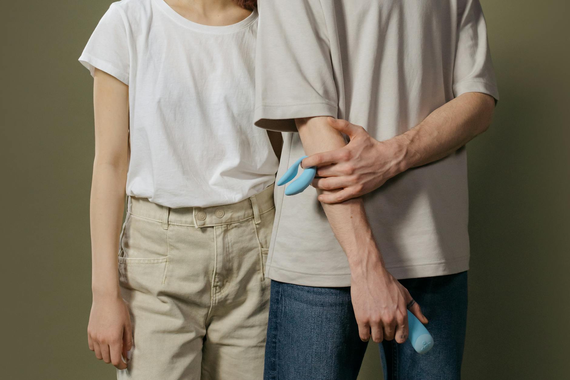A couple holding a blue vibrator together, representing partnership and shared exploration during hormonal awareness